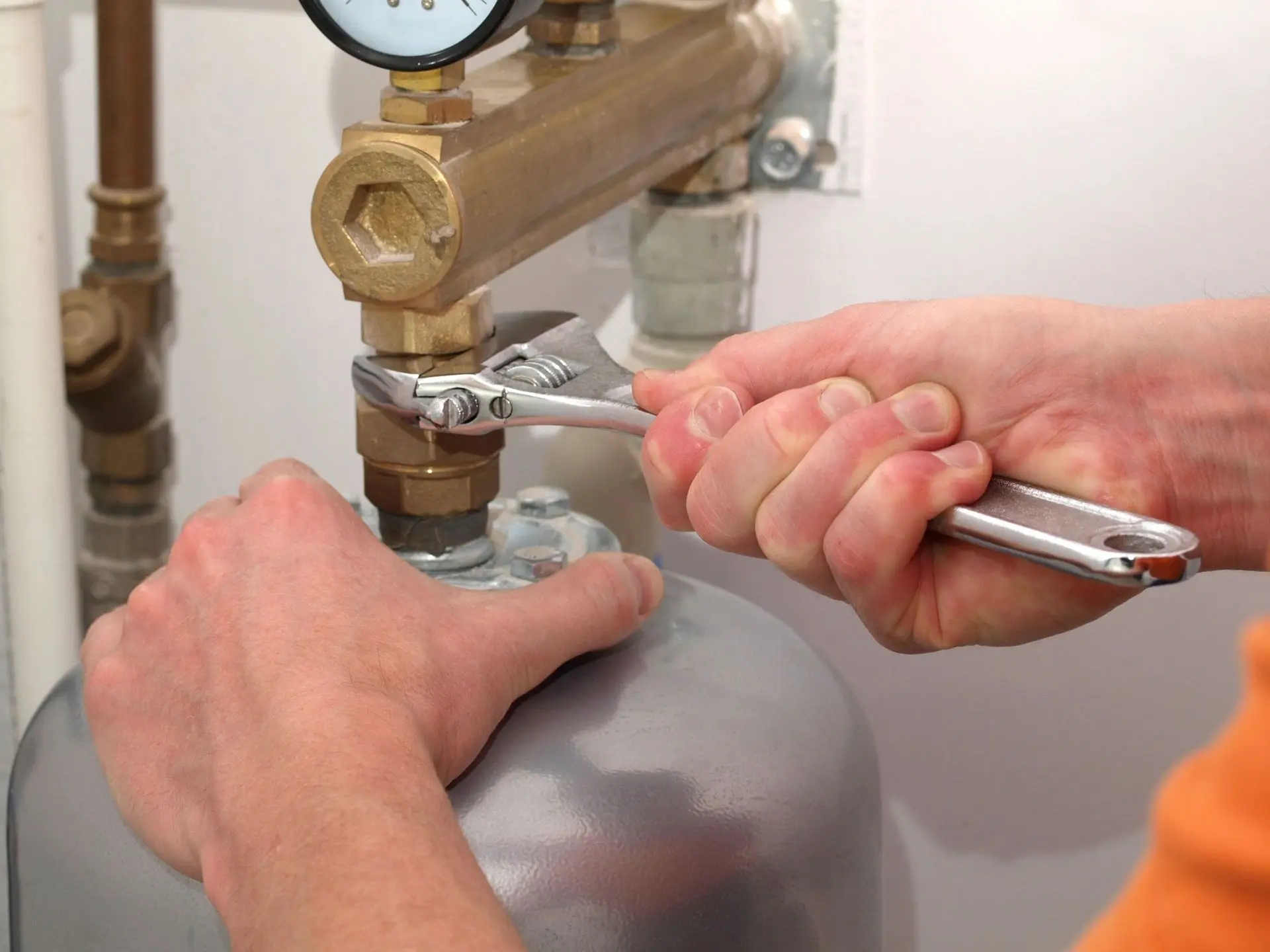 A person is working on the valve of a gas tank.